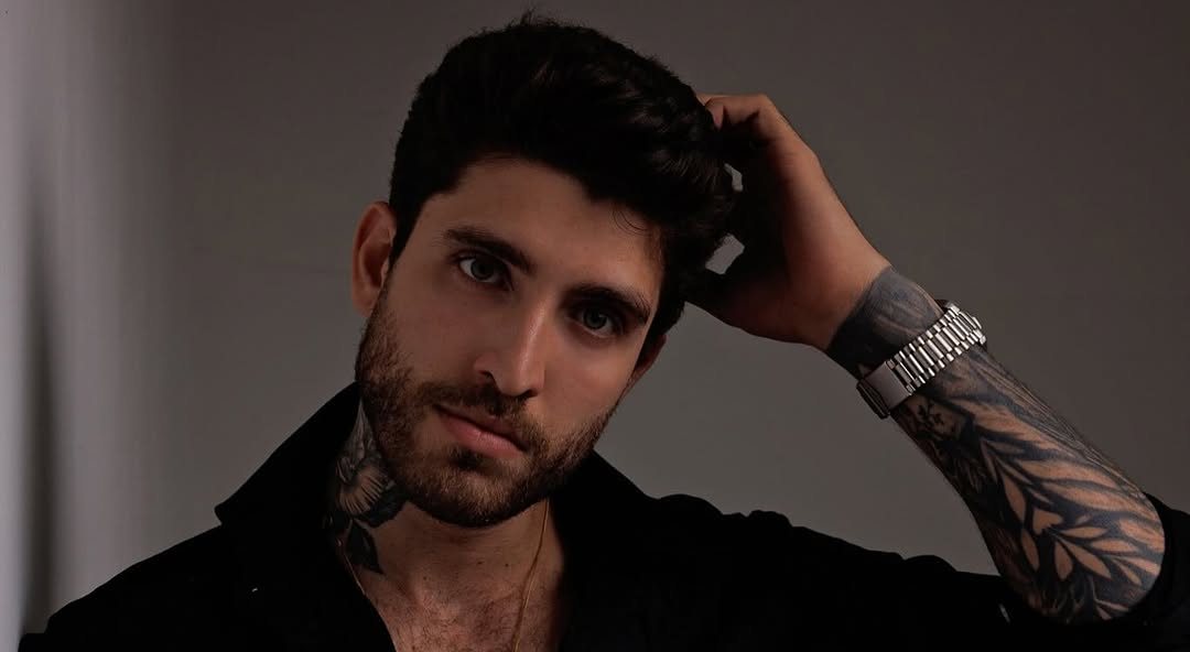 Igor Cuts de camisa preta, com a mão no cabelo